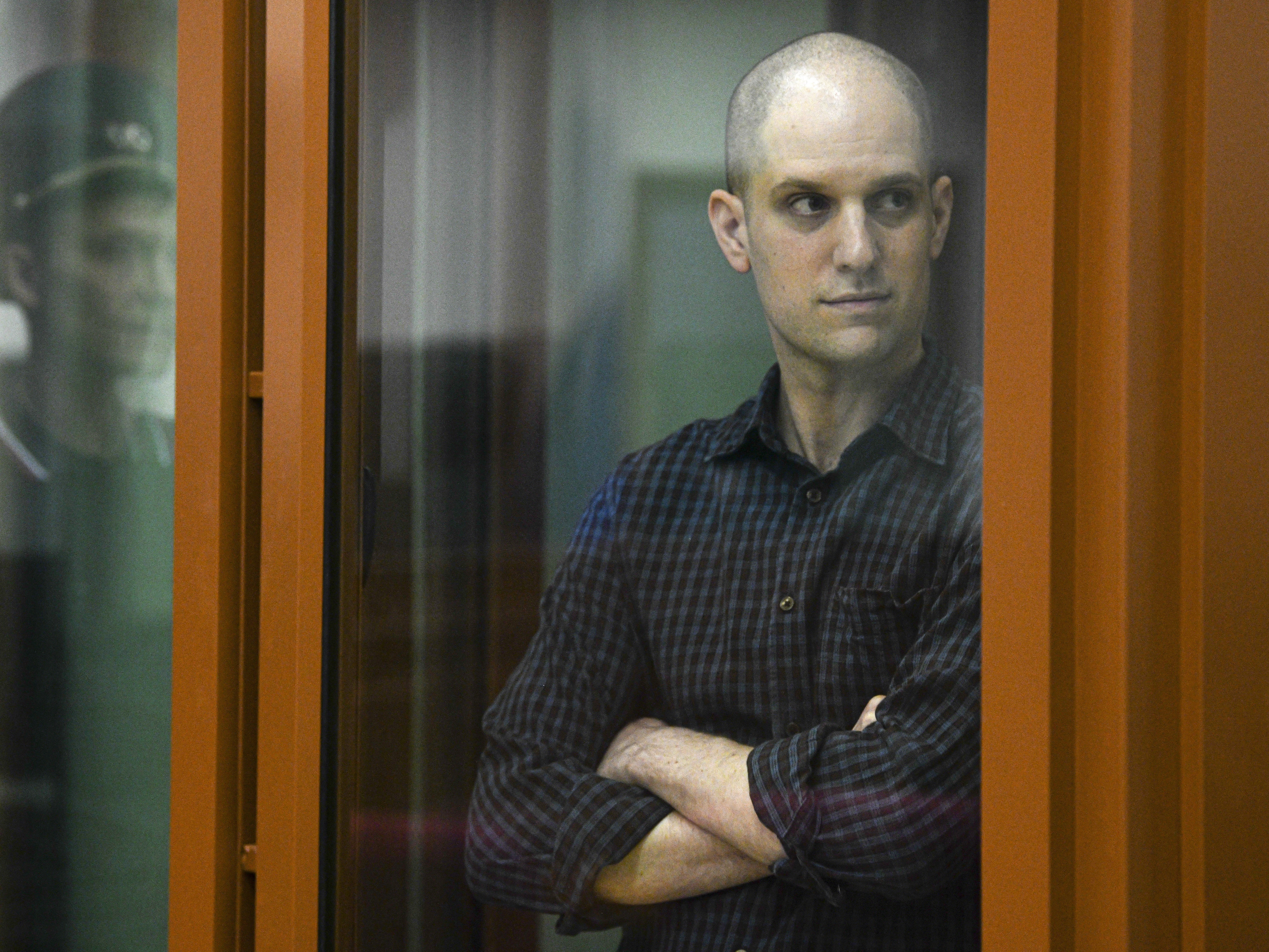 caption: <em>Wall Street Journal </em>reporter Evan Gershkovich stands in a glass cage in a courtroom in Yekaterinburg, Russia, June 26.