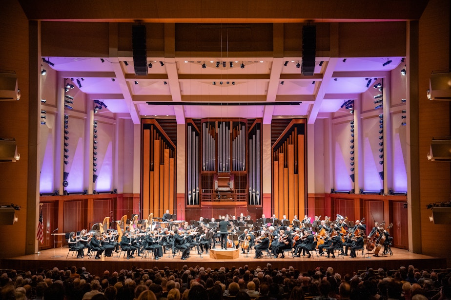 caption: The Seattle Symphony, led by Conductor Emeritus Ludovic Morlot, performing on stage in Benaroya Hall in 2023.