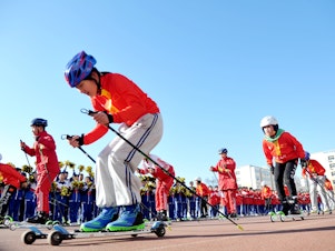 caption: Students from the Youth Winter Olympic Sports School perform ice and snow gymnastics during an event marking the 100-day countdown to the 2022 Winter Olympic Games in Zhangjiakou, Hebei province, China, on Tuesday.