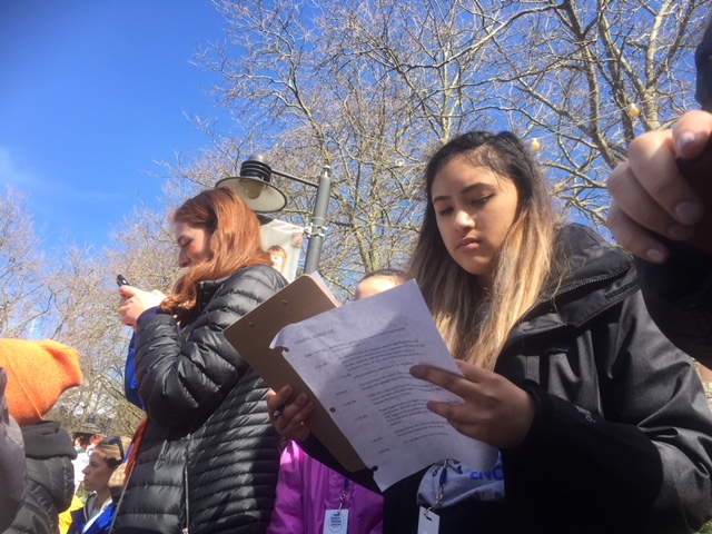 caption: Rhiannon Rasaretnam scribbles notes for her speech for Seattle's March for Our Lives before she goes on stage.