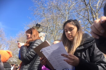 caption: Rhiannon Rasaretnam scribbles notes for her speech for Seattle's March for Our Lives before she goes on stage.