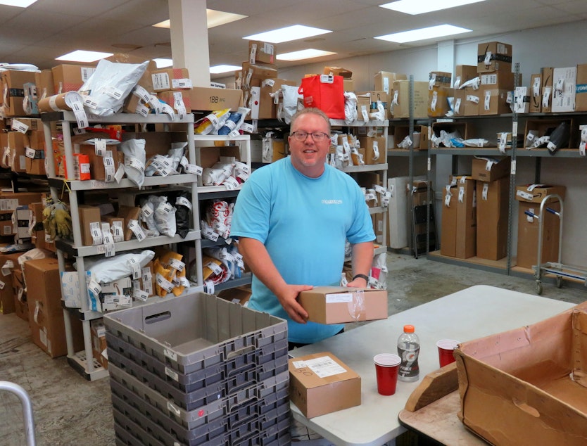 caption: Hagen’s of Blaine co-owner Steve Hagen in the receiving room of his busy mailing services business.