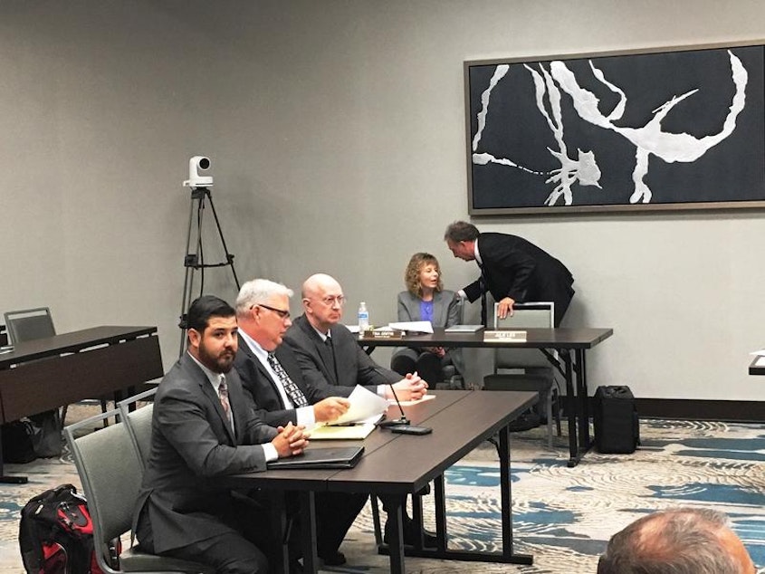 caption: Michael Herrera, left, and Bradley Kruger, center, of the National Rifle Association at a Washington State Gambling Commission Meeting
