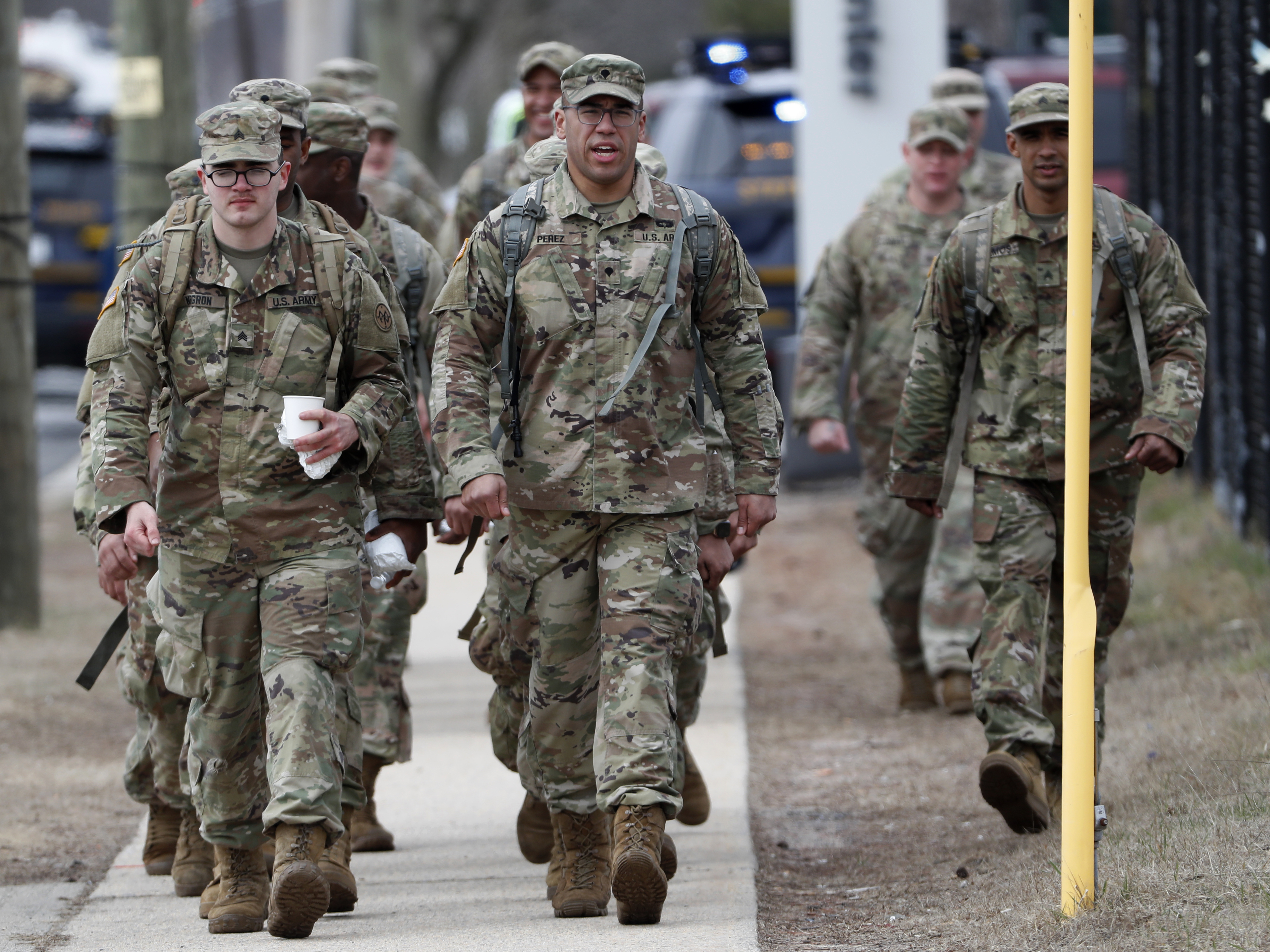 caption: National Guard personnel march in formation Thursday at a state-managed coronavirus drive-through testing site that just opened on Staten Island in New York.