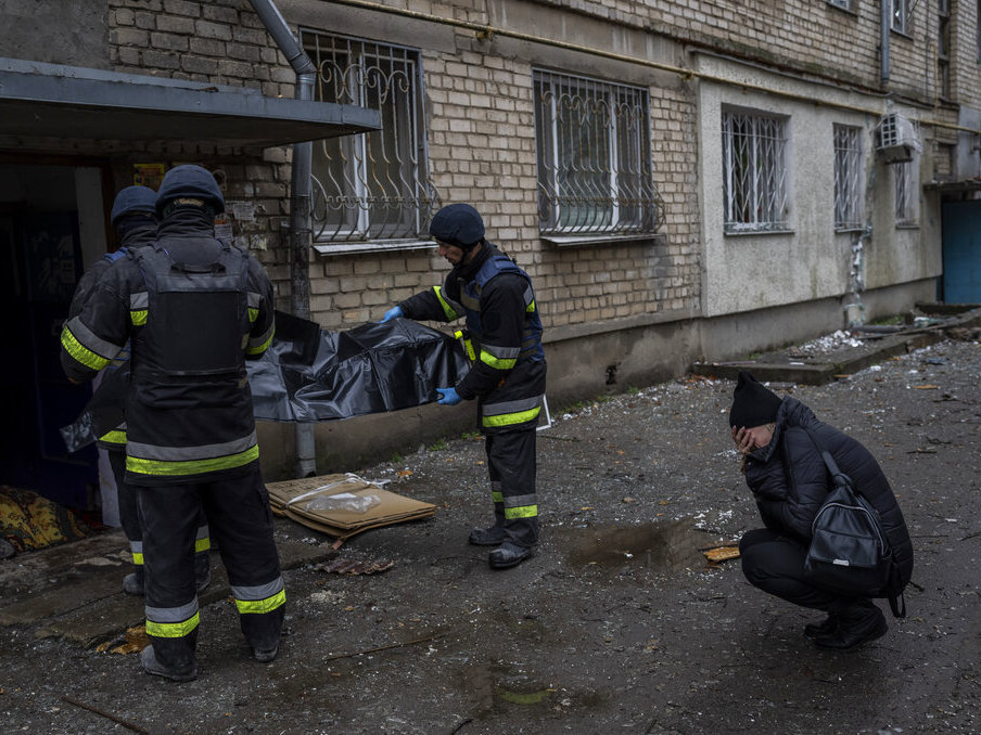 caption: Lilia Kristenko, 38, cries Friday as city responders collect the dead body of her mother Natalia Kristenko in Kherson, southern Ukraine. Natalia Kristenko's dead body lay covered in a blanket in the doorway of her apartment building for hours overnight. The 62-year-old woman had walked outside her home with her husband Thursday evening after drinking tea when the building was struck.