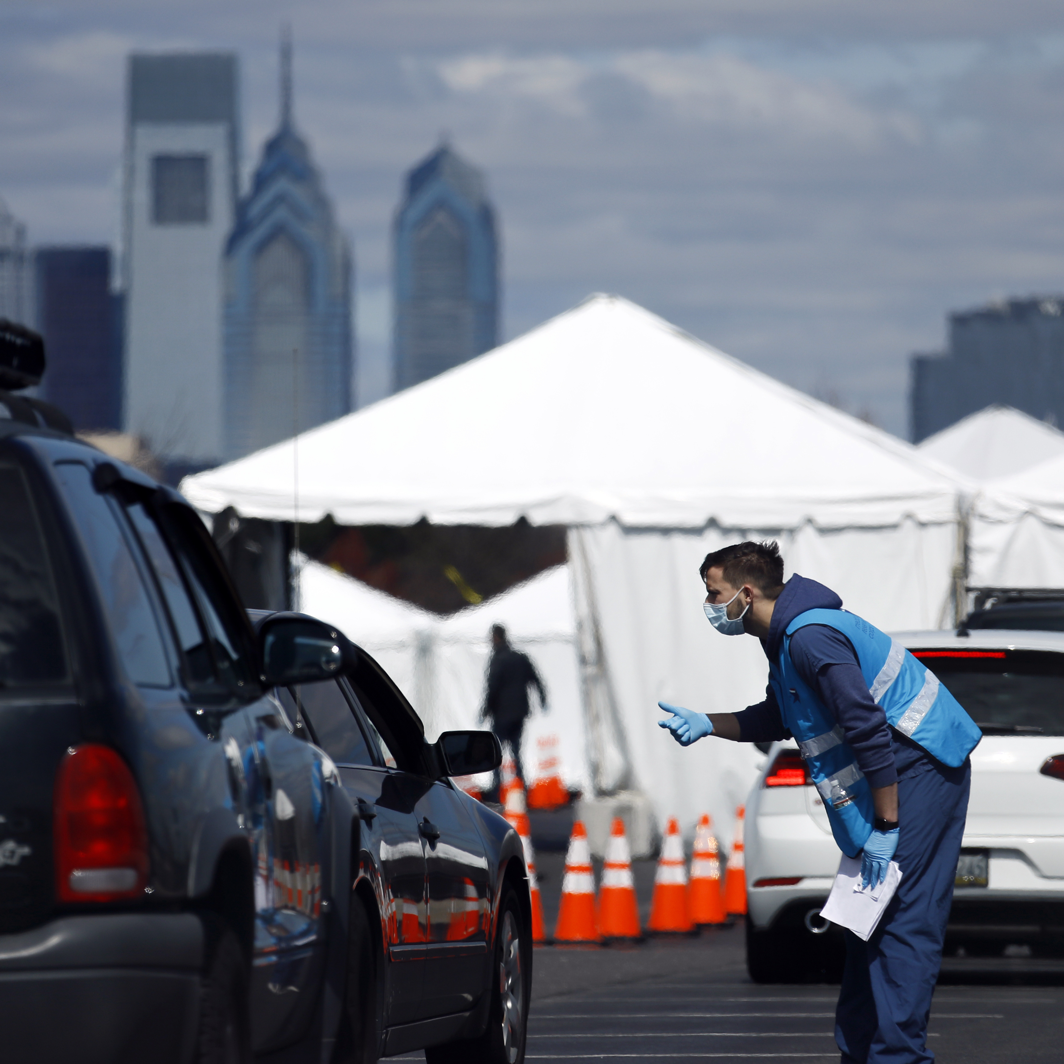 caption: A health care worker talks with a patient at a COVID-19 testing site in Philadelphia. The site will close Friday when the federal government ends support for this site and others around the country.