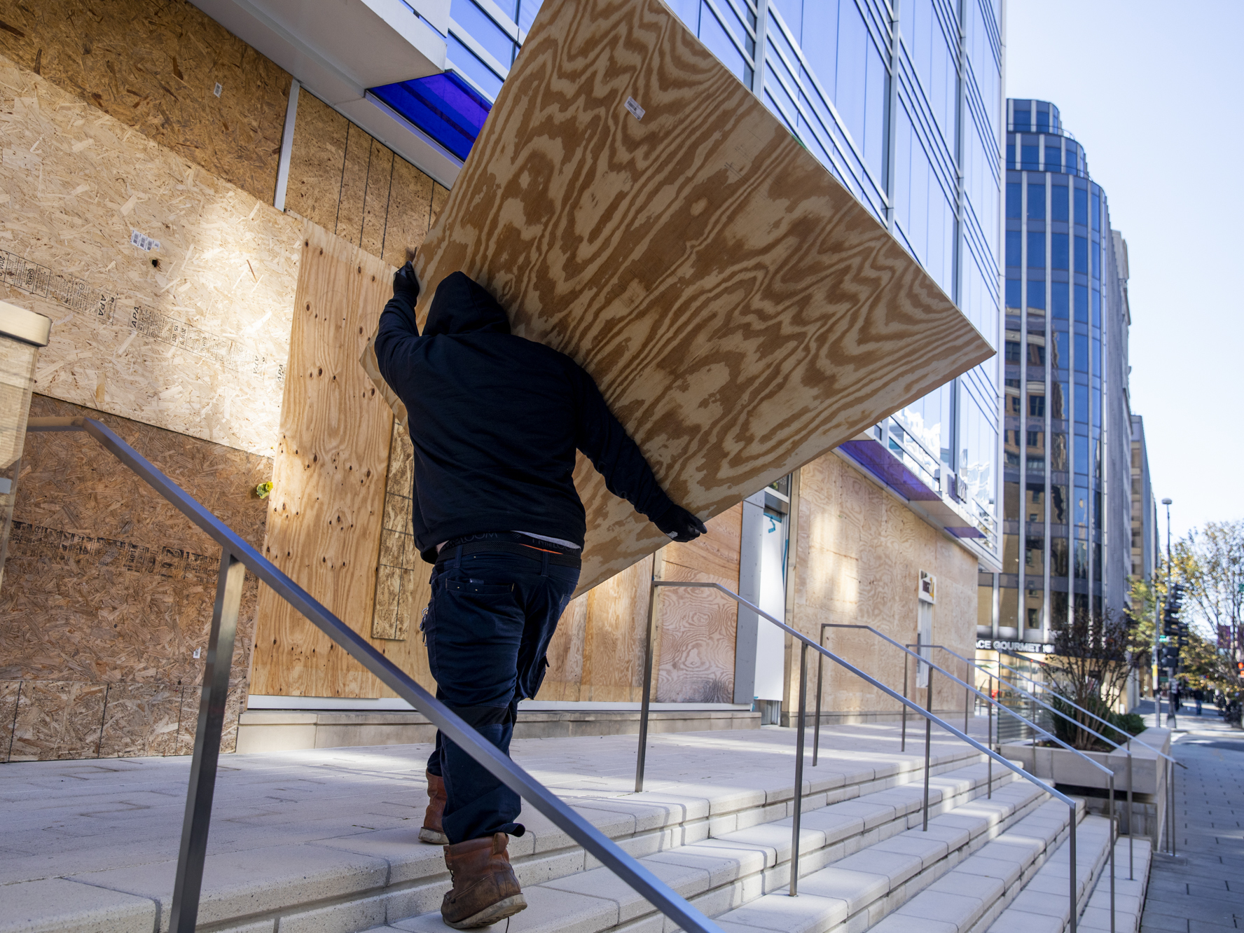 caption: Workers board up a building in downtown Washington, D.C., in preparation for possible protests.