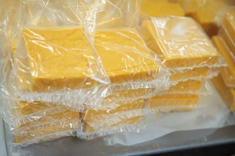 caption: Cheese is packaged for sale at Widmer's Cheese Cellars in 2016 in Theresa, Wis. Record dairy production in the U.S. has produced a record surplus of cheese causing prices to drop.