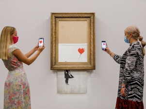 caption: Banksy's "Love is in the Bin" (2018) is installed at Sotheby's on September 03, 2021 in London, England.