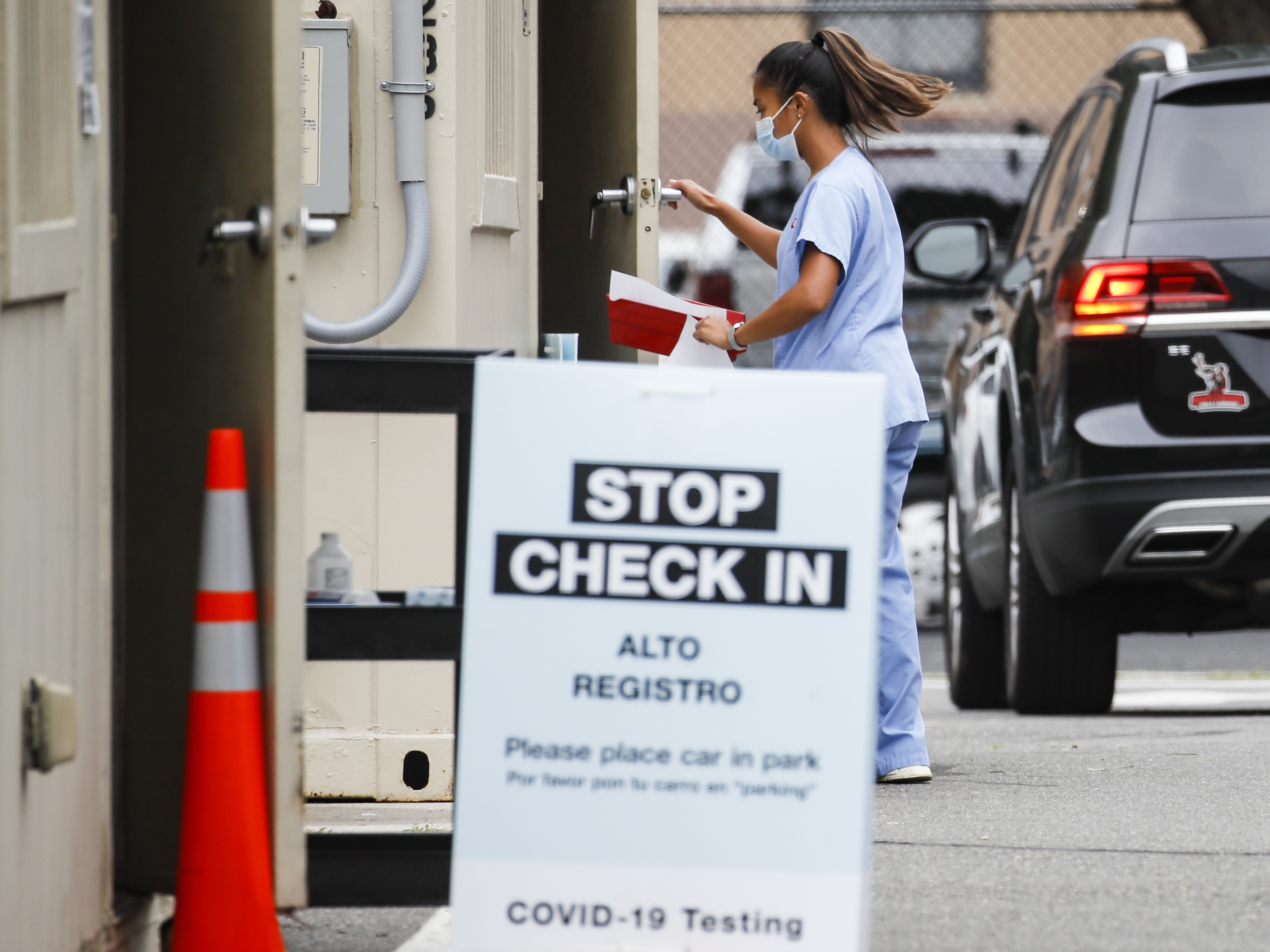 caption: Six states have an agreement to acquire fast-result antigen tests for the coronavirus. Here, a medical worker collects a sample after a patient self-administers a nasal swab test.