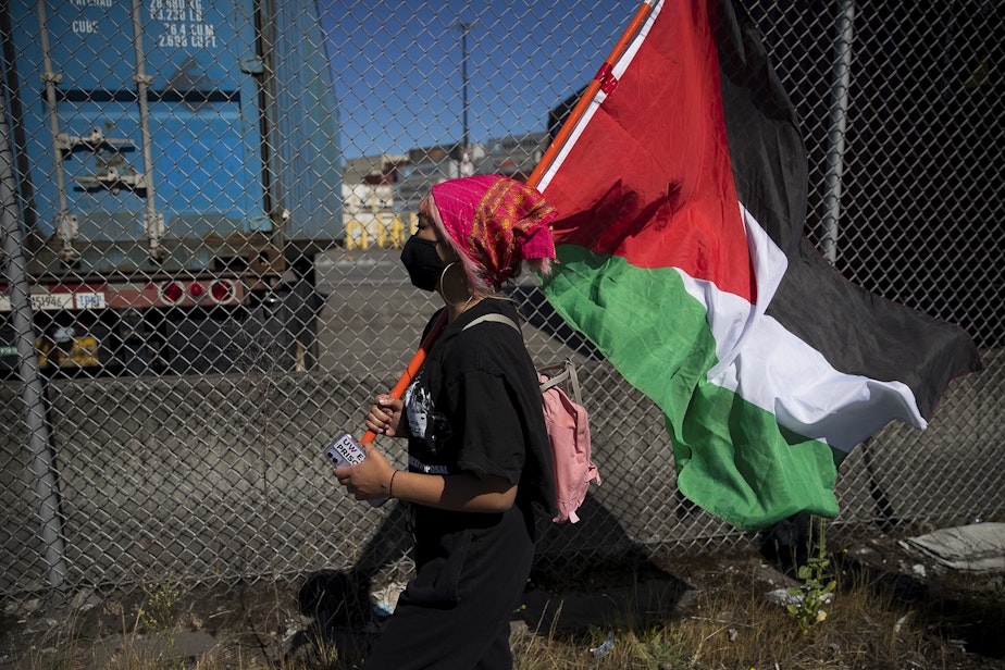 caption: Jasmine Fernandez marches alongside Palestinian activists and allies before blocking an intersection in protest of the Israeli Zim San Diego Vessel on Thursday, June 17, 2021, at the Port of Seattle.