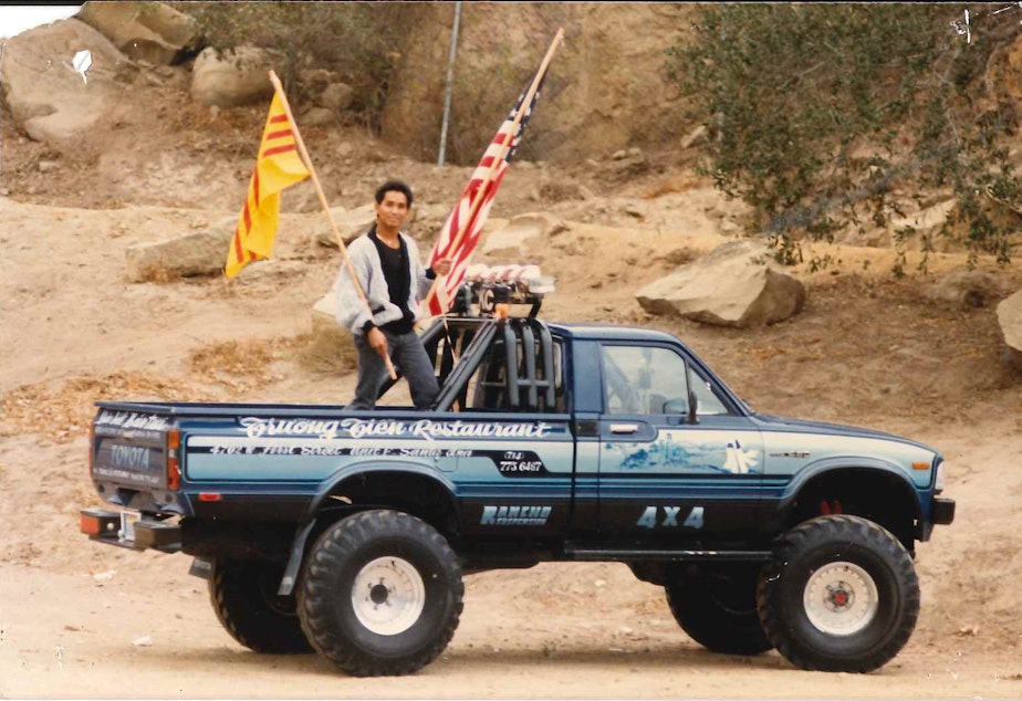 caption: Quang Adam Nguyen, Angela's dad, holding the South Vietnamese and American flags.