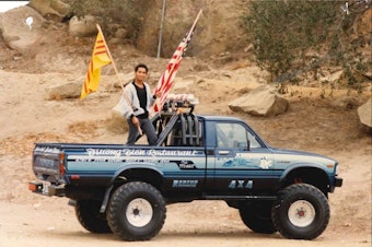 caption: Quang Adam Nguyen, Angela's dad, holding the South Vietnamese and American flags.