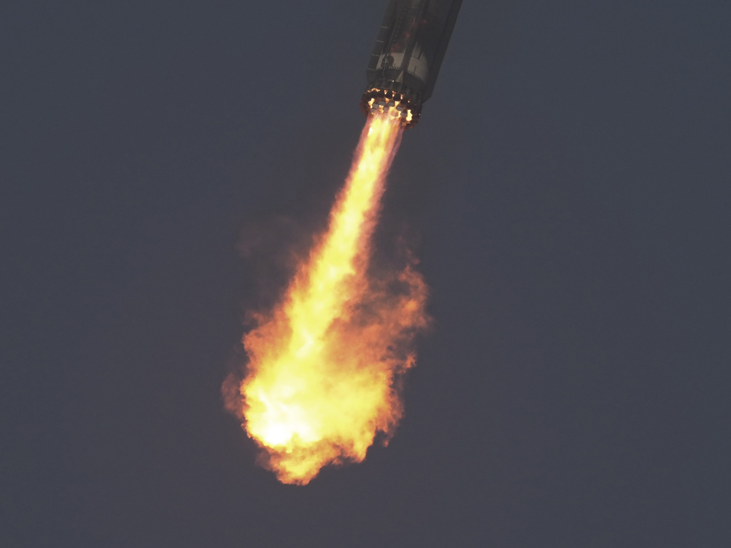 caption: The booster of SpaceX's mega rocket Starship is recaptured during a test flight from Starbase in Boca Chica, Texas, on Thursday.