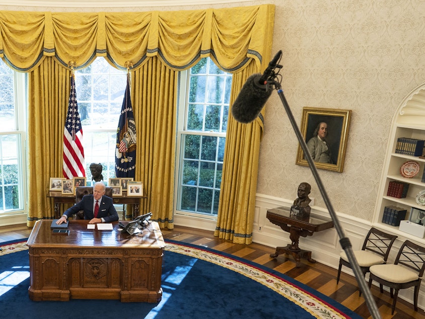 caption: U.S. President Joe Biden is seen in the White House Oval Office of in January 2021 in Washington, D.C., as Vice President Kamala Harris looks on.