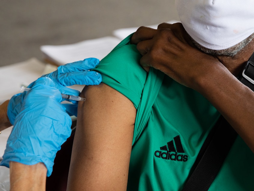 caption: Rufus Peoples receives a dose of the Pfizer-BioNTechCOVID-19 vaccine at an Oakland County Health Department vaccination clinic in Southfield, Mich., in August.