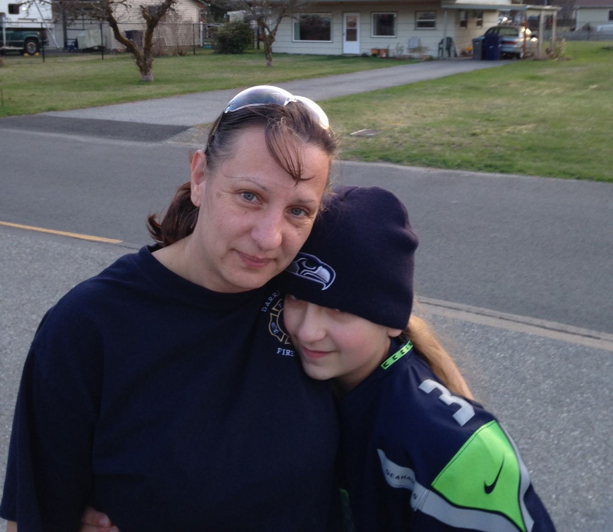 caption: Angela Botamanenko and her daughter Gaby after meeting players from the Seattle Seahawks and Sounders FC at the Darrington Community Center Monday.