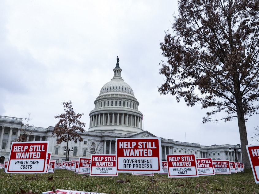 caption: Signs reading "Help Still Wanted" were positioned on the lawn outside the U.S. Capitol on Jan. 5. The House Budget Committee meets Monday afternoon, setting up a vote on the coronavirus relief package by the end of the week.