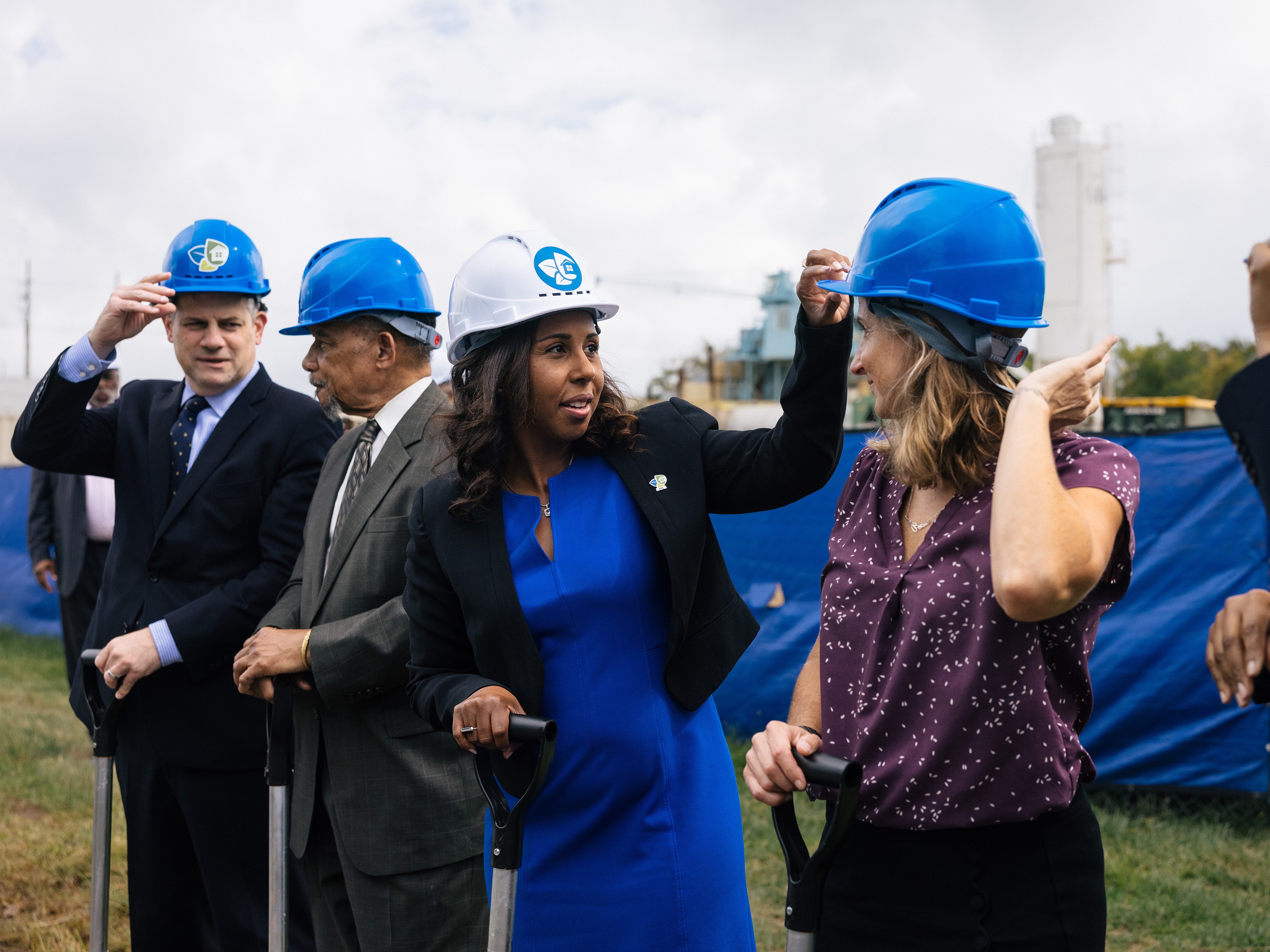 caption: Chelsea Andrews (white hat), president and executive director of Montgomery County's<strong> </strong>Housing Opportunities Commission, adjusts Maryland State Delegate Lorig Charkoudian's hardhat during a groundbreaking ceremony for the Hillandale Gateway housing development in Silver Spring, Md. The HOC says it owns more than 9,400 apartment, townhome and single-family home rental properties and provides subsidized housing for more than 9,300 households.