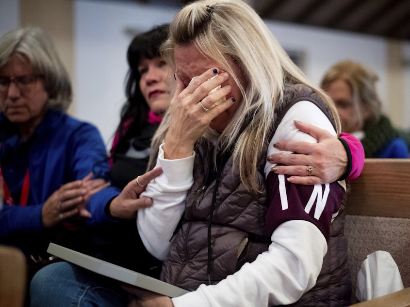 caption: Laura Martin mourns her father, TK Huff, who died during the Camp Fire, during a vigil on Sunday in Chico, Calif.