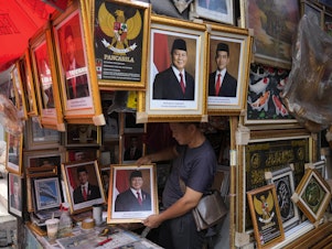 caption: A vendor holds a portrait of Indonesian President-elect Prabowo Subianto at a market in Jakarta, Indonesia, April 24.