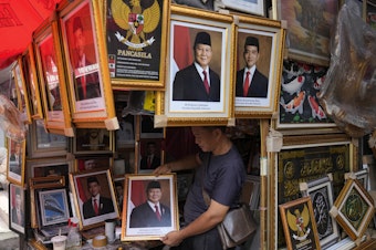 caption: A vendor holds a portrait of Indonesian President-elect Prabowo Subianto at a market in Jakarta, Indonesia, April 24.