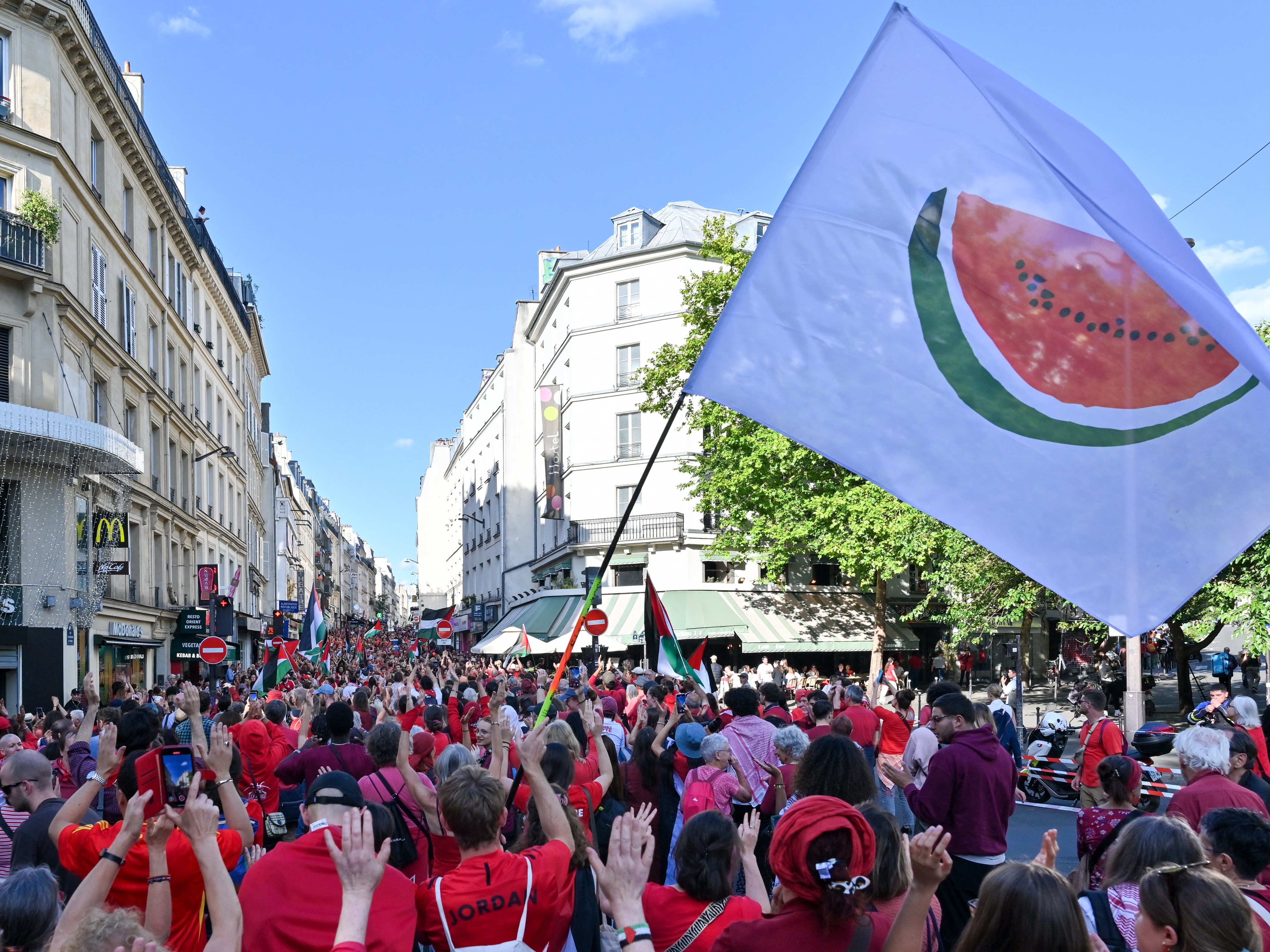caption: A flag with a watermelon, a symbol of Palestinian identity, is waved during the Red Line for Gaza protest in Paris on July 8.