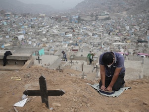 caption: A relative prays at the Mártires 19 de Julio Cemetery on the outskirts of Lima, Peru, on Aug. 20. Peru has one of the highest per capita coronavirus-related death tolls in the world, according to Johns Hopkins University.