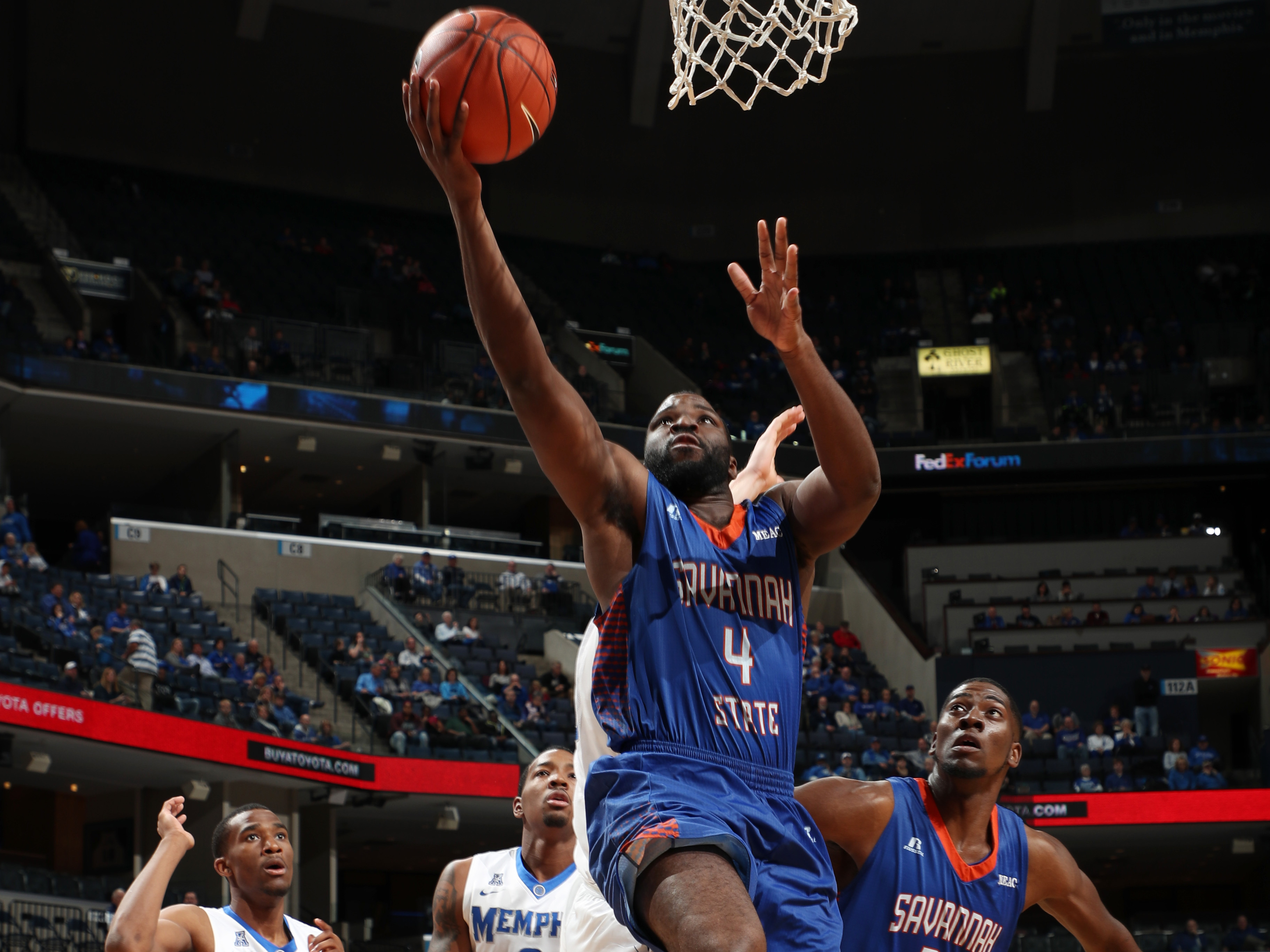 caption: Troyce Manassa #4 of the Savannah State Tigers shoots a layup against the Memphis Tigers at FedExForum in Memphis in 2016.