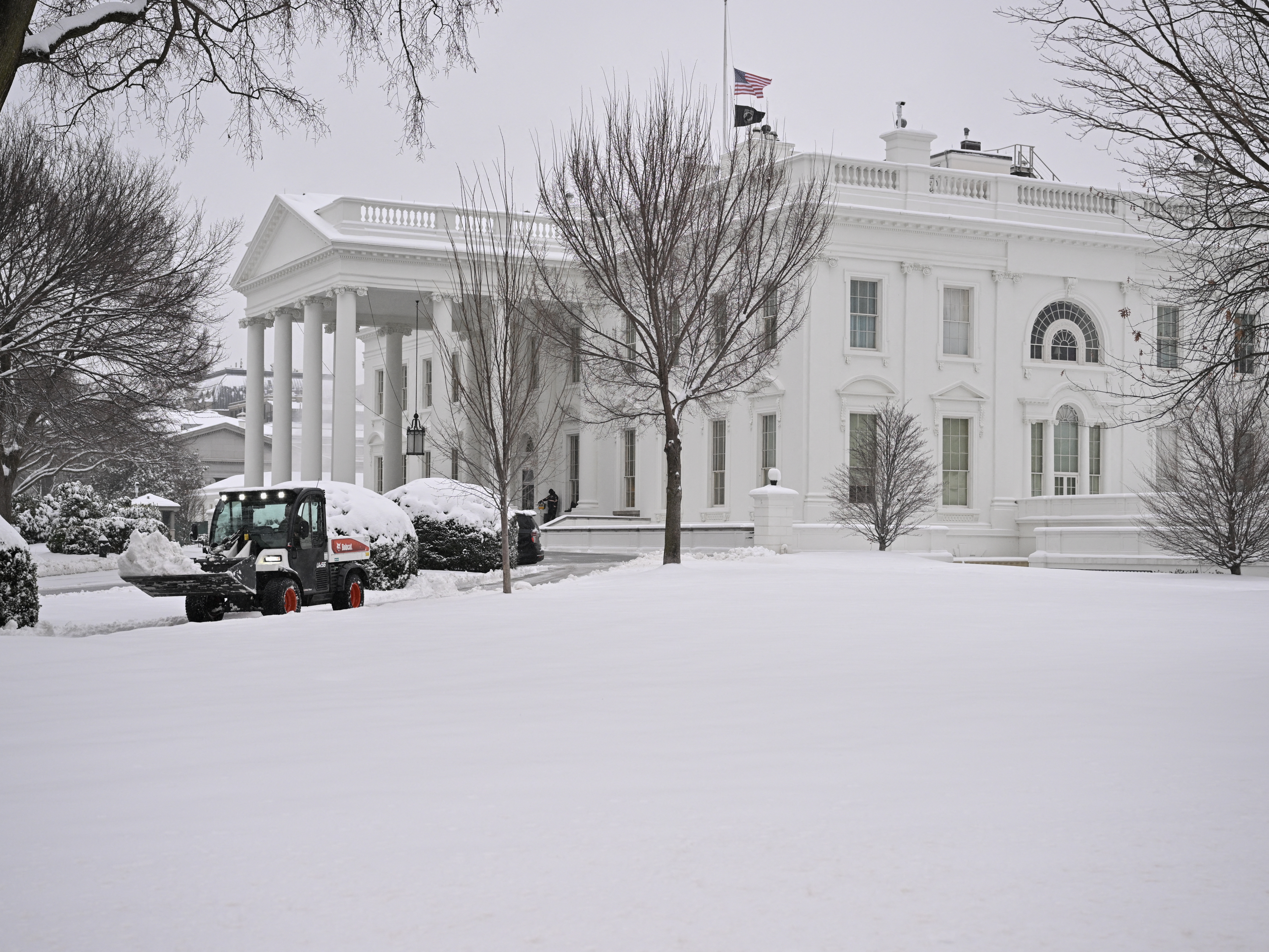 caption: Workers remove snow from a sidewalk at the White House this month. A massive storm system dumped heavy snow and freezing rain on large swaths of the eastern United States, bringing an unusual amount to snow to the region.