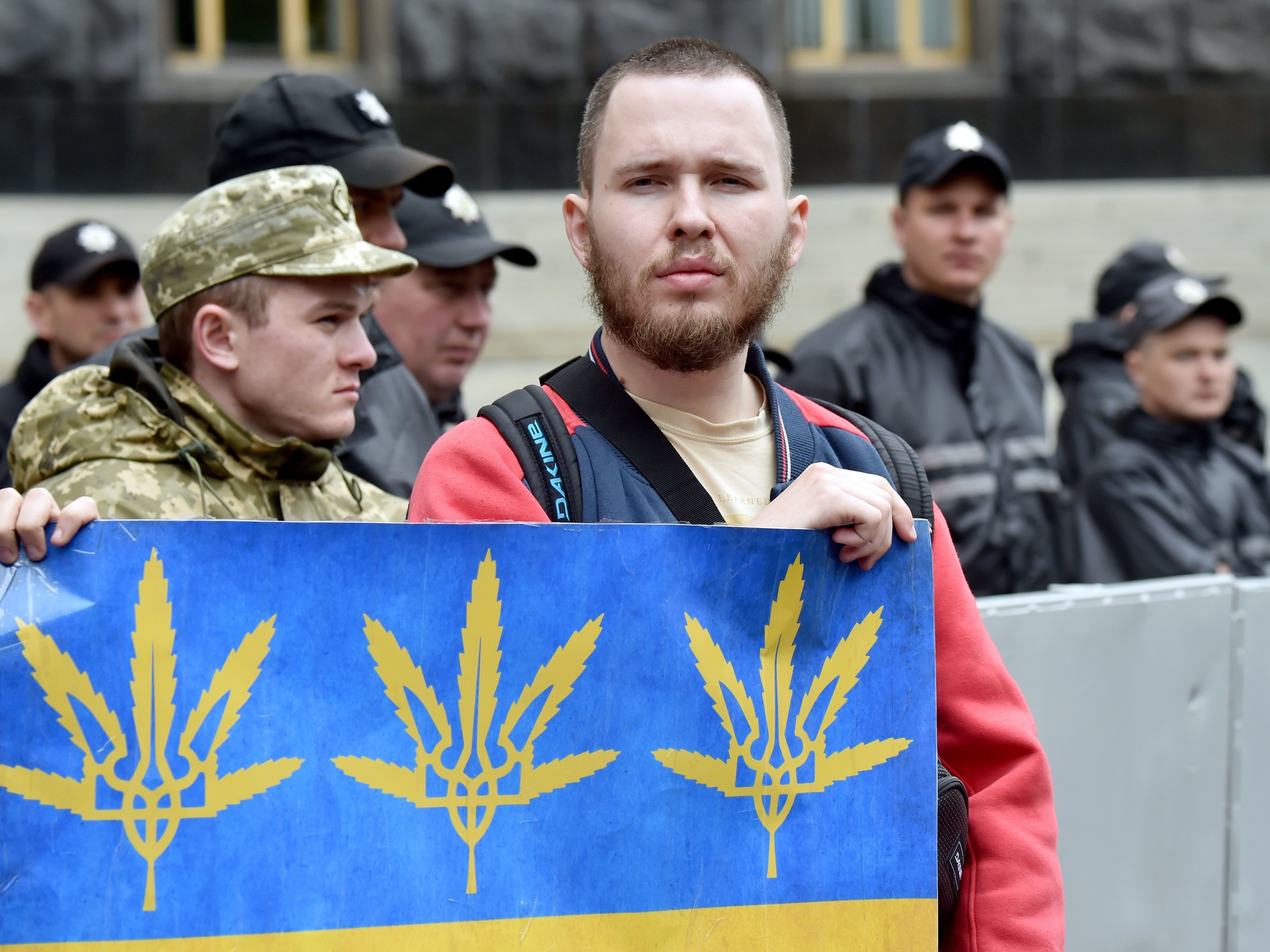 caption: An activist holds a placard depicting cannabis leaves during a protest in Kyiv in May 2017. Ukraine is moving closer to legalizing medical cannabis, fueled in part by Russia's war.