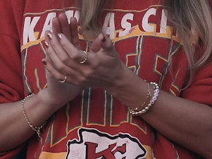 caption: Taylor Swift wears a friendship bracelet with Kansas City Chiefs tight end Travis Kelce's number 87 while watching a game between the Kansas City Chiefs and the Los Angeles Chargers on Oct. 22, 2023, in Kansas City, Mo.