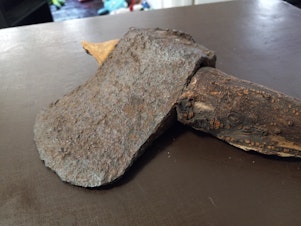 caption: Matthew Decker discovered this ax with a root for a handle in his front yard.