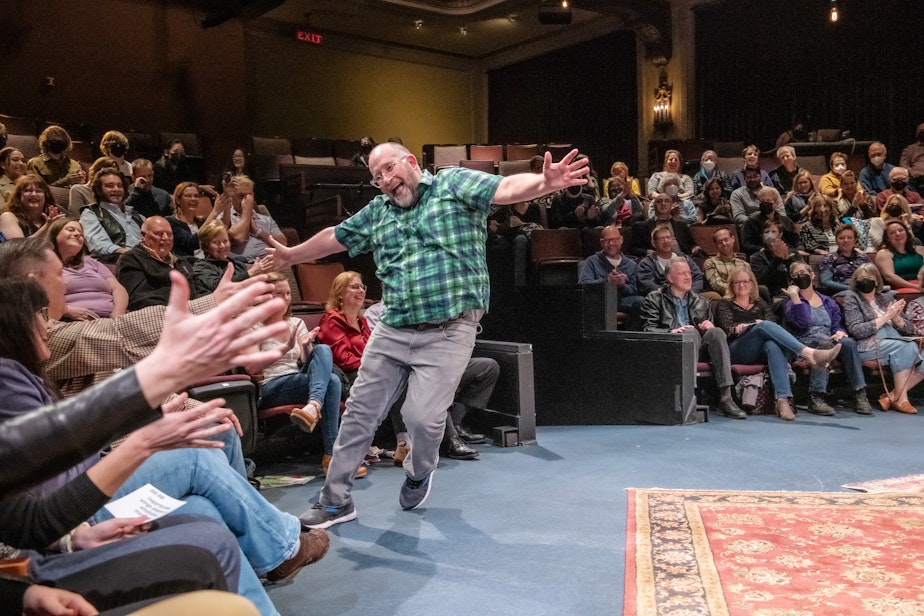 caption: Ian Bell high-fives the entire room in Every Brilliant Thing, by Duncan Macmillan with Jonny Donahoe and directed by John Langs, onstage March 23-April 2, 2023 at ACT—A Contemporary Theatre. 