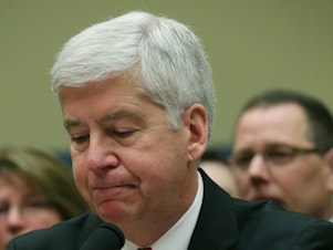 caption: Now Former Michigan Gov. Rick Snyder, (R-MI), listens to Congressional members remarks during a House Oversight and Government Reform Committee hearing, about the Flint, Mich. water crisis in 2016.