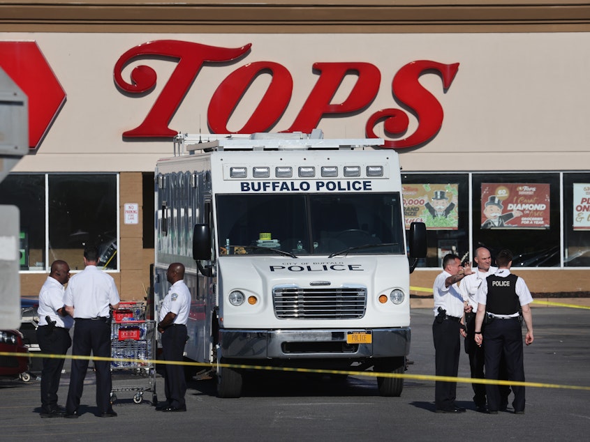 caption: Police and FBI agents continue their investigation of the shooting at Tops market on Sunday in Buffalo, N.Y. A gunman opened fire at the store killing ten people and wounding another three on Saturday.