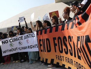 caption: Demonstrators hold a sign reading "end fossil fuels" at the COP28 U.N. Climate Summit, Friday, Dec. 8, 2023, in Dubai, United Arab Emirates. (AP Photo/Peter Dejong)