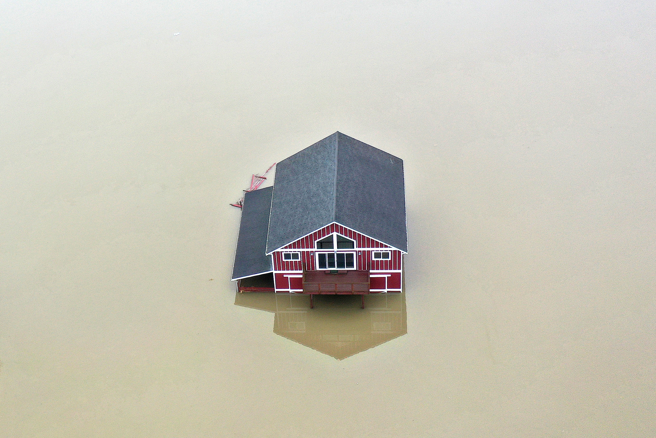 caption: A home is shown completely surrounded by floodwater on Friday, December 12, 2025, in Snohomish. Catastrophic conditions continue to threaten Western Washington as an atmospheric rivers sweep through the Pacific Northwest.