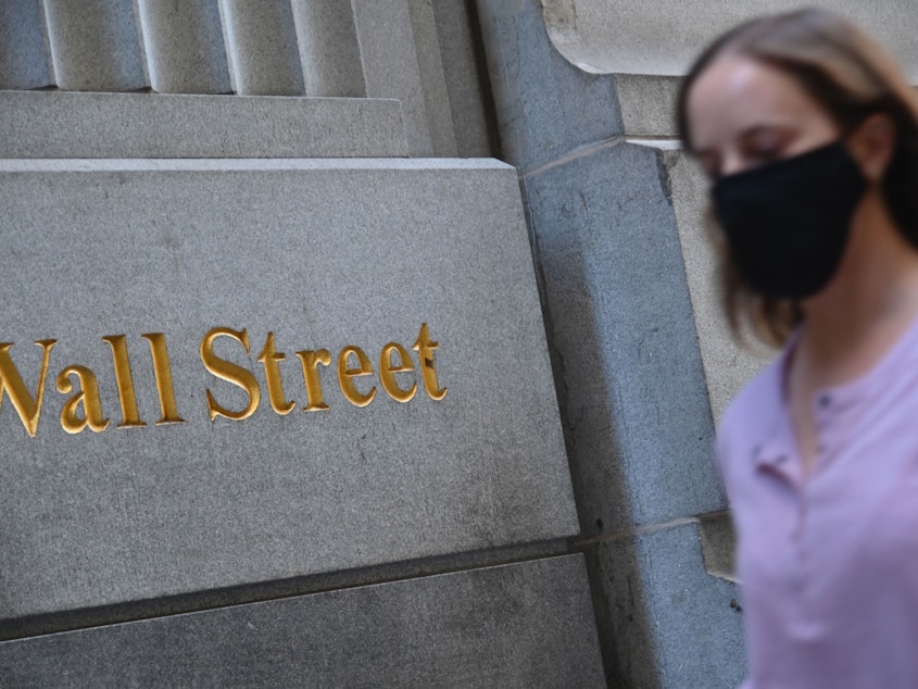 caption: A woman walks by the New York Stock Exchange on Oct. 5. Stock markets are rallying at the prospect this week's elections will result in a divided government.