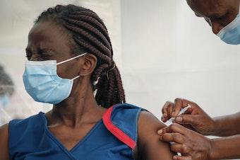 caption: A front-line worker in Kenya receives a shot of the AstraZeneca COVID-19 vaccine. African Families for Holistic Health Organization in Portland, Ore., hopes that the work they do in the U.S. will help curb vaccine misinformation back in Africa.