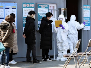 caption: People suspected of being infected with the coronavirus wait for diagnostic tests at a medical center in Daegu, South Korea.