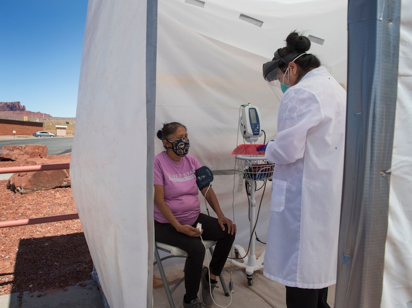 caption: A nurse checks vitals for a Navajo woman, who came to a coronavirus testing center in Arizona, complaining of virus symptoms.