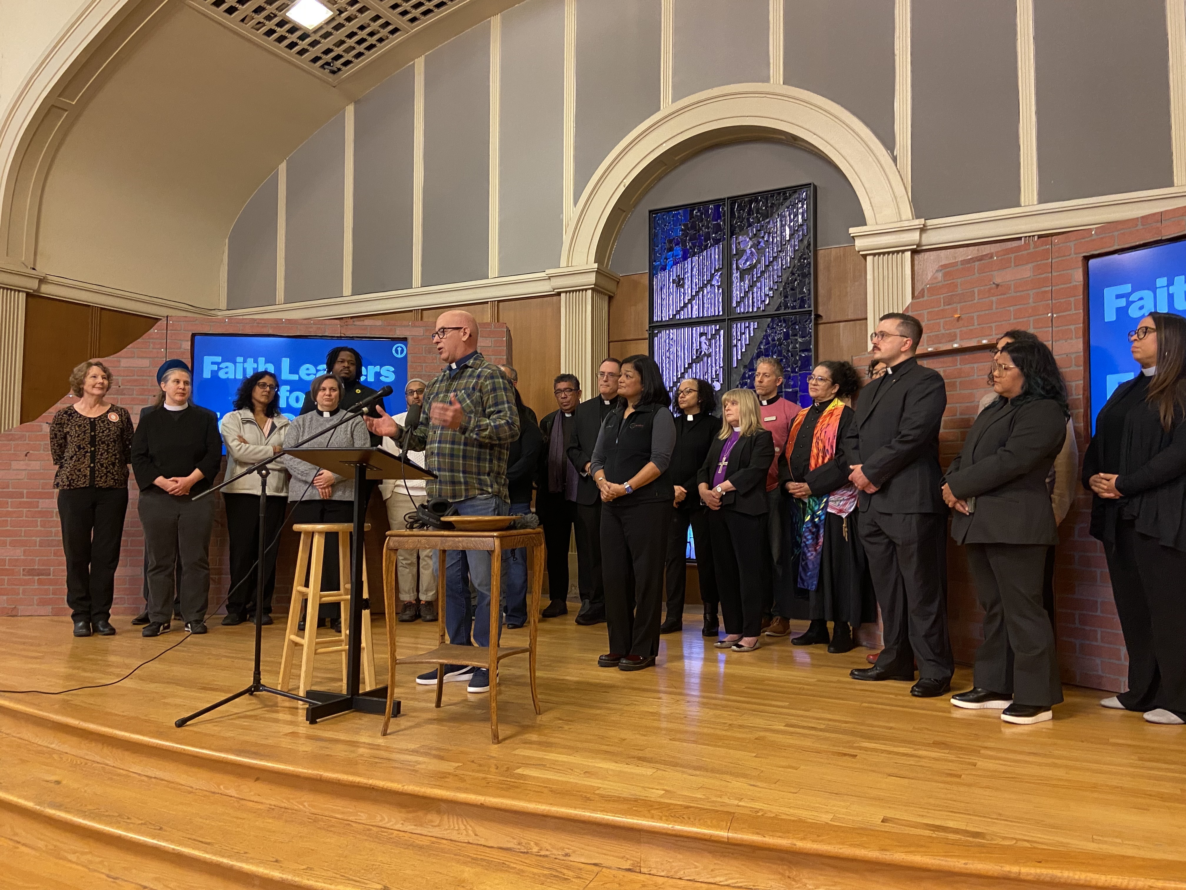 caption: All Pilgrims Christian Church Pastor Greg Turk (center) speaks alongside Rep. Pramila Jayapal about the impacts of partial SNAP benefits on Nov. 3, 2025. 
