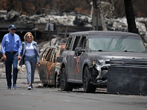 caption: President Biden and first lady Jill Biden view damage caused by wildfires in Lahaina, Hawaii on August 21, 2023. The president is expected to travel to see hurricane damage Florida on Saturday.