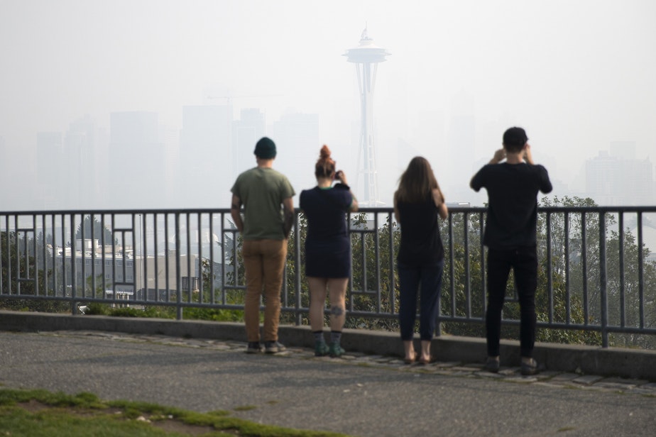 caption: People photograph a smoke covered downtown Seattle as a massive plume of smoke from wildfires burning in California and Oregon made it's way into the area on Friday, September 11, 2020, at Kerry Park in Seattle. 
