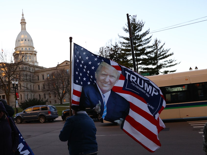caption: Supporters of then-President Donald Trump gather outside the Michigan State Capitol in 2020.