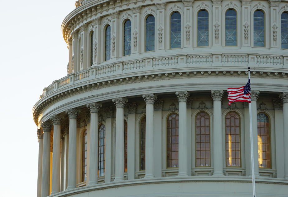 caption: A flag flies in front of the U.S. Capitol in Washington, D.C.