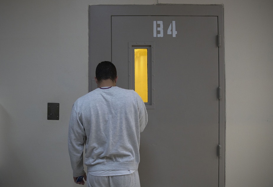 caption: A detainee stands while waiting for a door to unlock on Tuesday, September 10, 2019, at the Northwest Detention Center, recently renamed the Northwest ICE Processing Center, in Tacoma. 