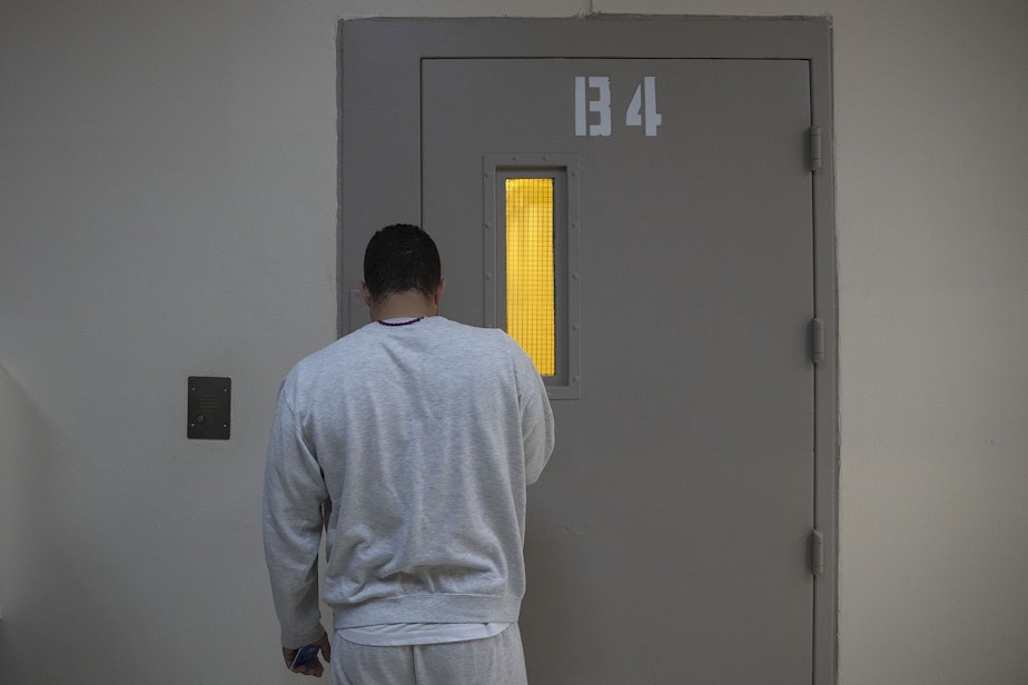 caption: A detainee stands while waiting for a door to unlock on Tuesday, September 10, 2019, at the Northwest Detention Center, renamed the Northwest ICE Processing Center, in Tacoma. 