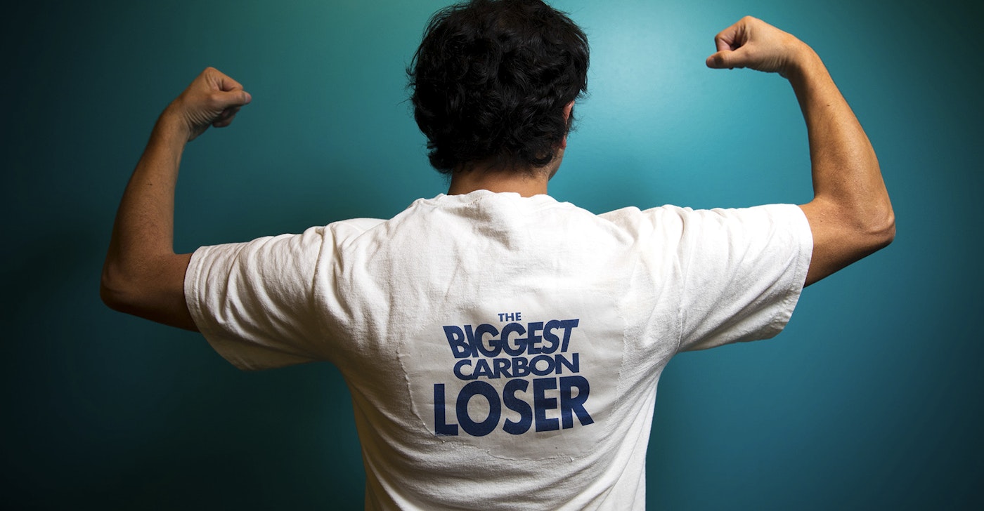 caption: KUOW's Juan Pablo Chiquiza poses in a Biggest Carbon Loser t-shirt.